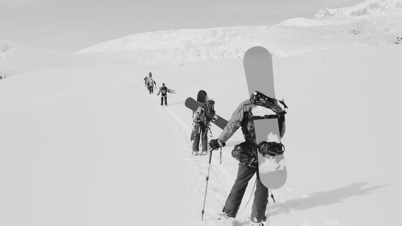 jeunes snowboarders à pieds en direction du sommet des pistes